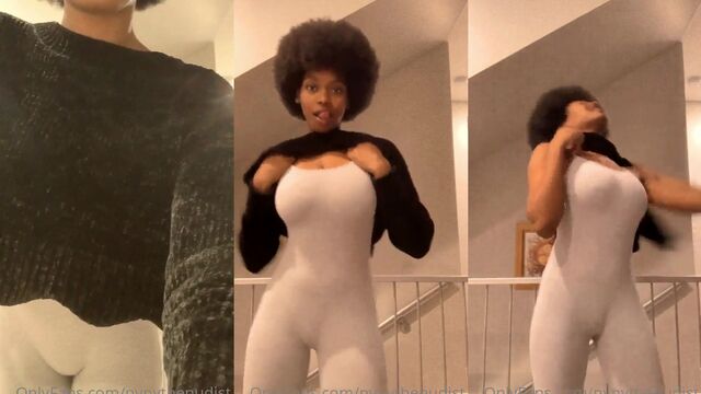 A sexy black woman performs a sensual strip tease with her beautiful breasts