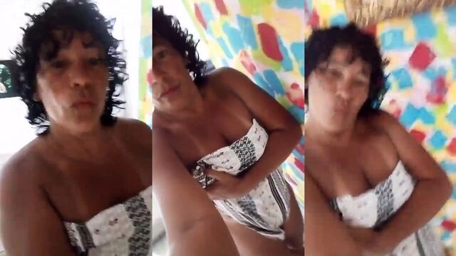 Brazilian milf Dinha enjoys herself on the bed in a sexy dress