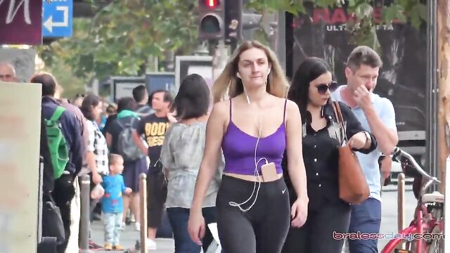 A beautiful woman is jogging and showing her breasts in public