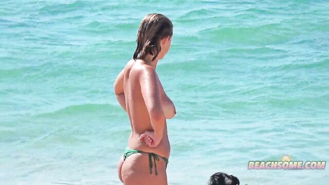A stunning bikini-clad girl is having fun with her mom on the beach