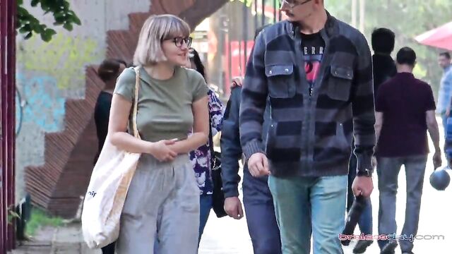 A woman walks the city with her breasts half-naked