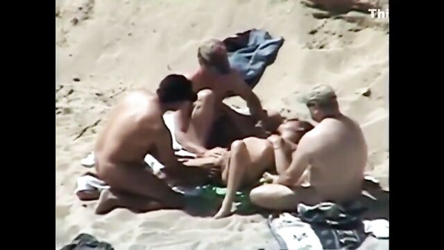 A couple has sex on the beach while strangers watch and enjoy