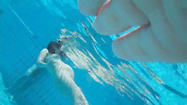 A couple has fun in the swimming pool, getting caught