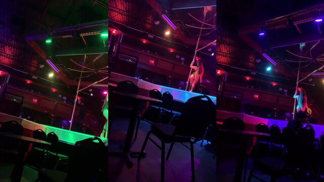 A fat ass woman is dancing on the strip pole in a club