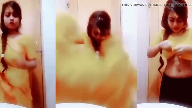 An Indian girl is stripping her saree and showing her body