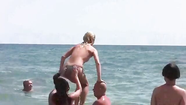 A naked woman on the beach sunbathes without any clothes