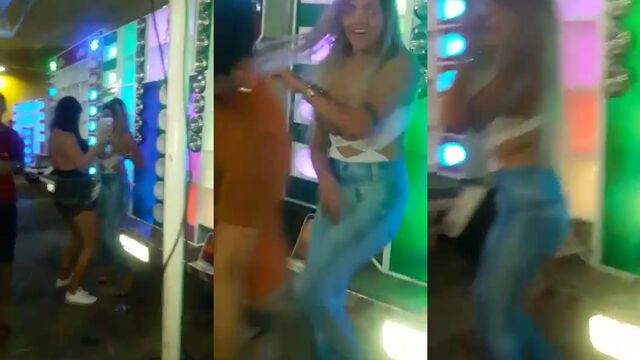 A skinny blonde shakes her tits on a fence while dancing, getting so wet