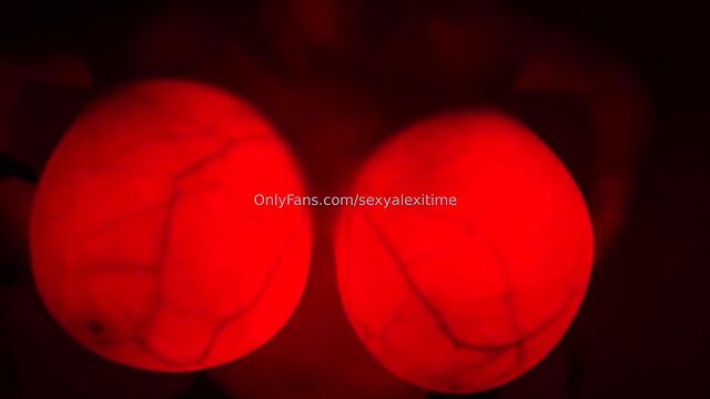 A hot chick plays with a large beach ball and her boobs